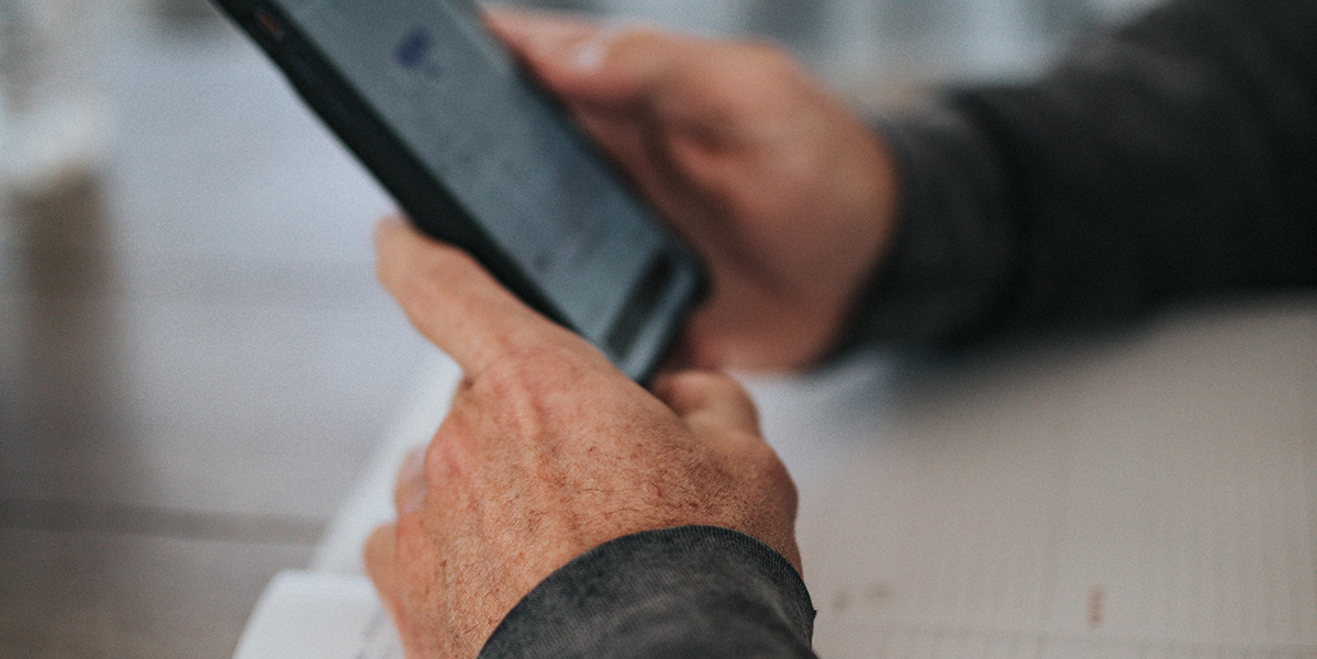 man holding a phone sat at a desk