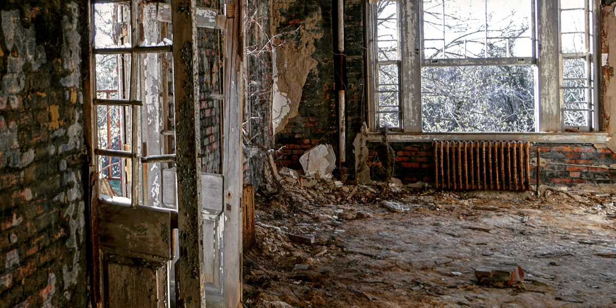 open rotten door in a decaying house