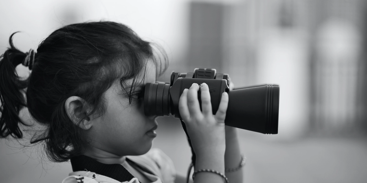 Little girl looking through binoculars