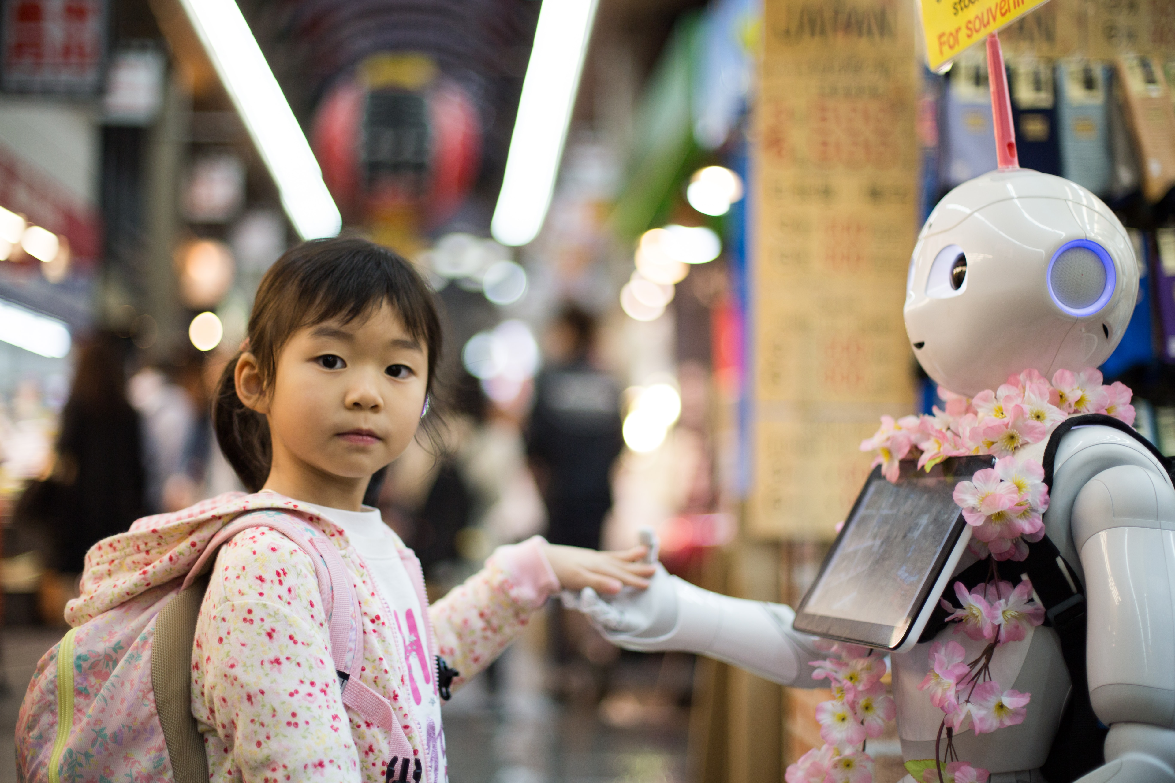 girl shaking hands with a robot