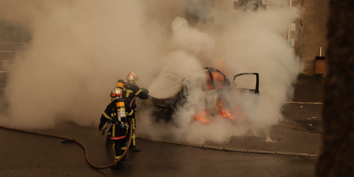 fire fighters putting out a burning car